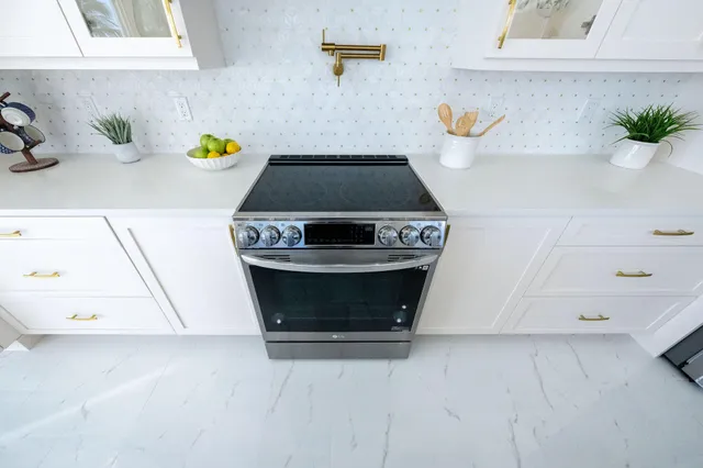 a bedroom with a bed a chandelier and a window