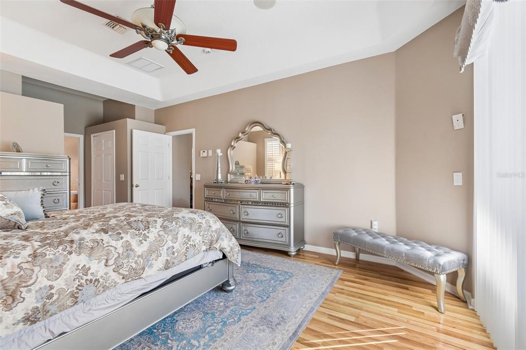 1602 Kish Boulevard Trinity, FL 34655 - Photo 18 of 65 a bedroom with a bed a dresser and a chandelier