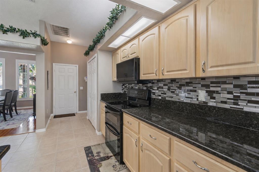 1602 Kish Boulevard Trinity, FL 34655 - Photo 24 of 65 a kitchen with granite countertop a sink a stove and cabinets