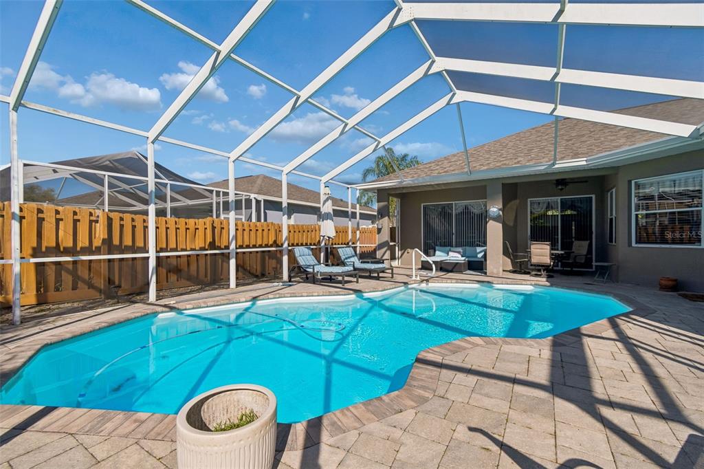 1602 Kish Boulevard Trinity, FL 34655 - Photo 58 of 65 a view of a backyard with table and chairs under an umbrella