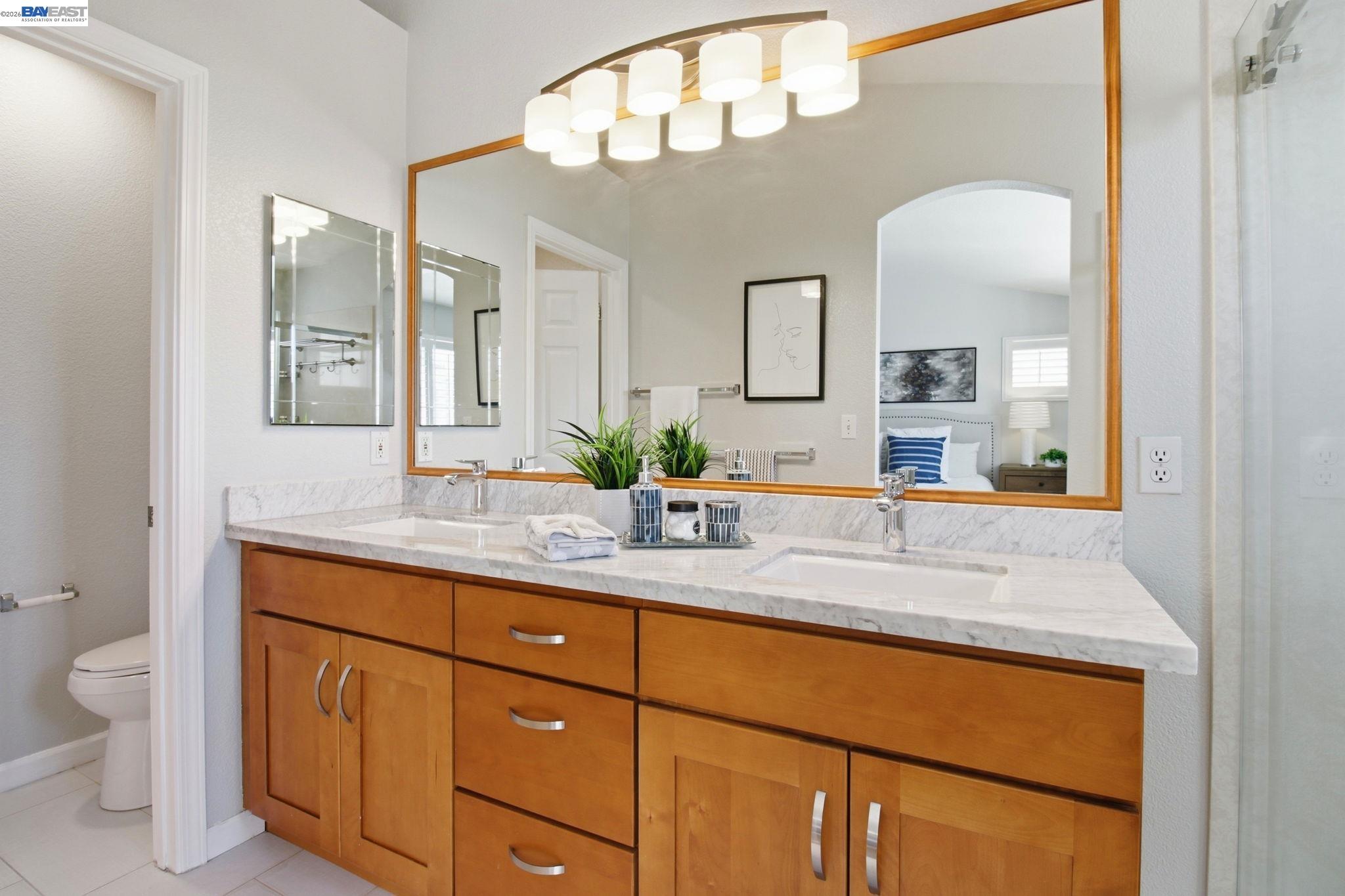 672 Greylyn Drive San Ramon, CA 94583 - Photo 26 of 35 a bathroom with a granite countertop sink a toilet and mirror
