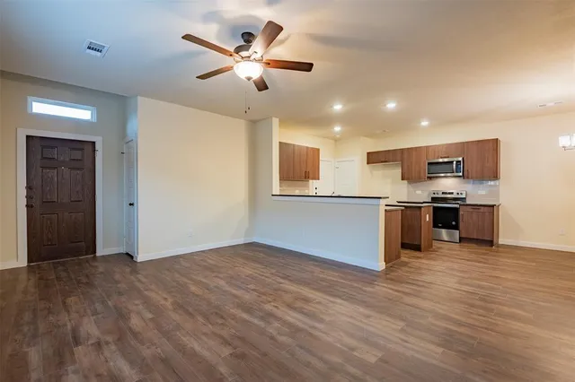 a view of a hallway with wooden floor