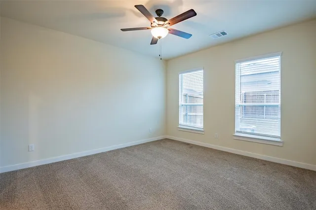 an empty room with closet and a chandelier fan