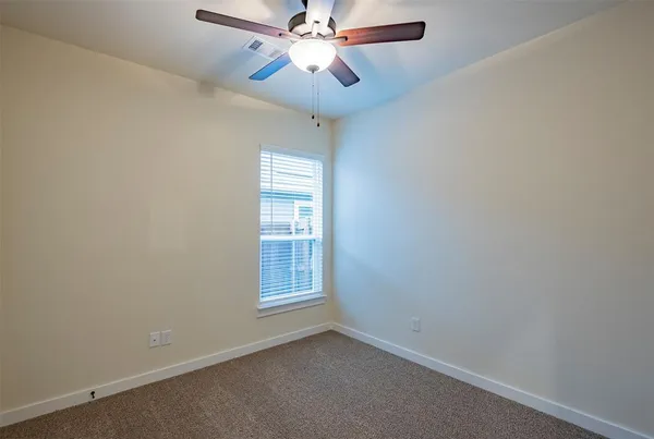 a view of a room with a ceiling fan and a ceiling fan