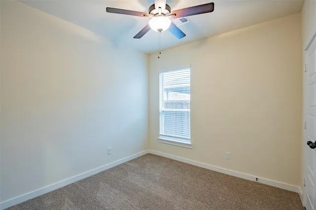 an empty room with a ceiling fan and a fan