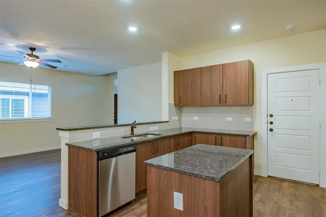 a kitchen with stainless steel appliances granite countertop a stove a microwave and a sink