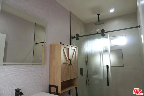 a bathroom with a glass shower door and a mirror