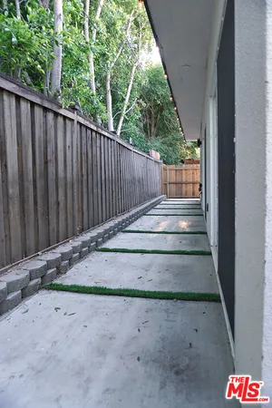 a view of small backyard with wooden fence