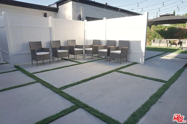 a view of a patio with table and chairs potted plants with wooden floor