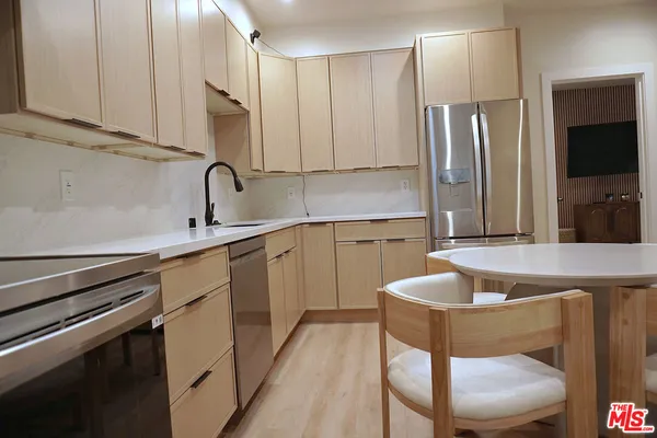 a kitchen with stainless steel appliances granite countertop a sink refrigerator and microwave