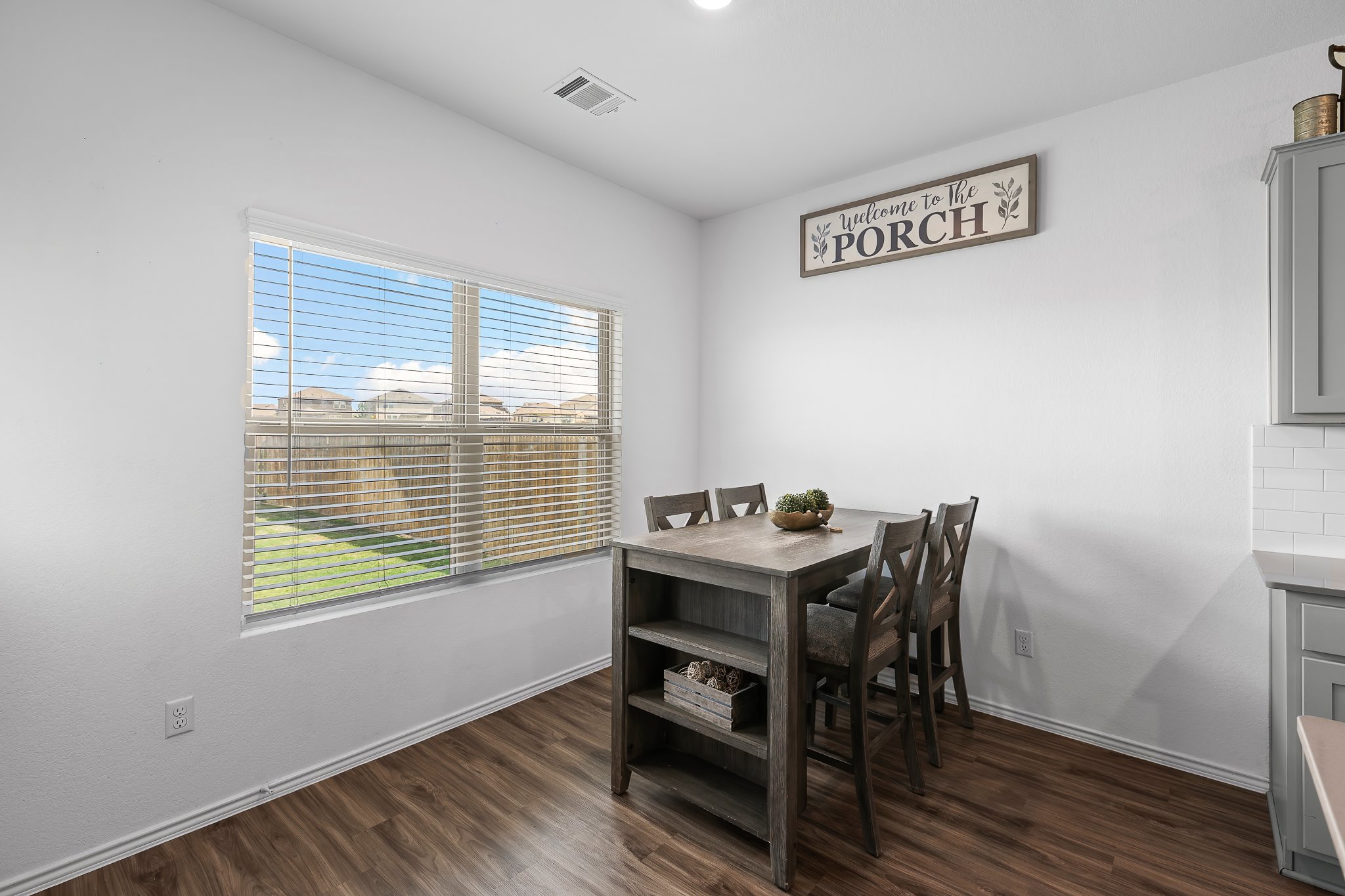 576 Greatest Gift Way Jarrell, TX 76537 - Photo 12 of 37 Hardwood-style flooring and natural light create a welcoming eating area.