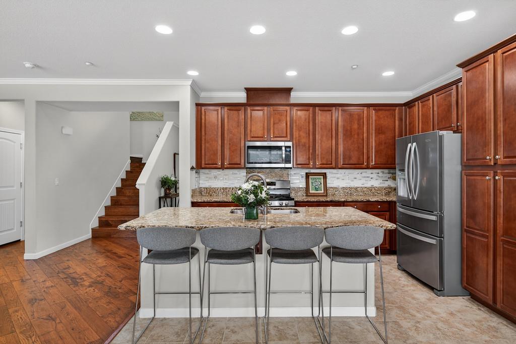 5409 Mill Water Circle Rancho Cordova, CA 95742 - Photo 19 of 48 a kitchen with stainless steel appliances kitchen island granite countertop a refrigerator and microwave