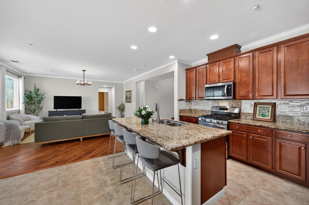 5409 Mill Water Circle Rancho Cordova, CA 95742 - Photo 20 of 48 a living room with stainless steel appliances granite countertop furniture wooden floor and a view of kitchen