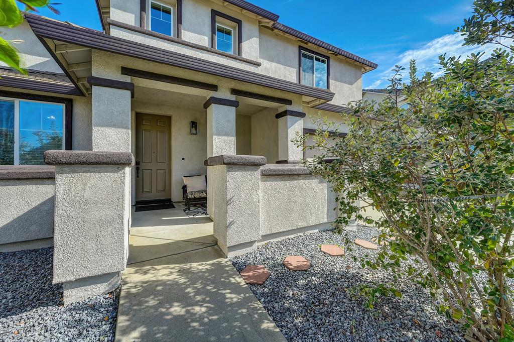 5409 Mill Water Circle Rancho Cordova, CA 95742 - Photo 7 of 48 a view of a white house with large windows and a tree