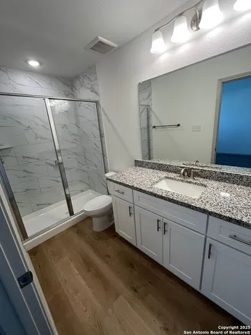 a spacious bathroom with a granite countertop sink toilet and shower