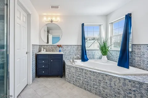 a spacious bathroom with a granite countertop sink a mirror and a shower