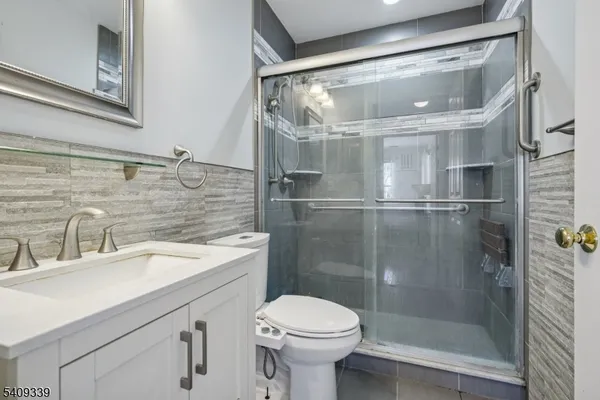 a bathroom with a tub shower sink and mirror