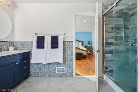 a bathroom with a tub shower sink and mirror