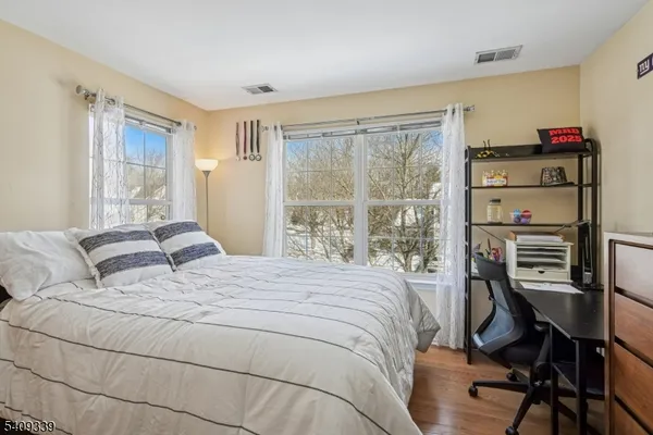 a bedroom with a bed a chair and a large window