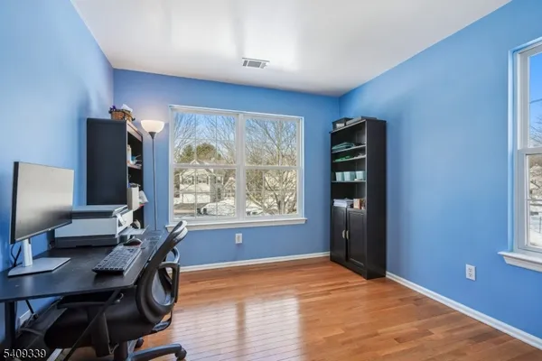 a view of a workspace with furniture and a window