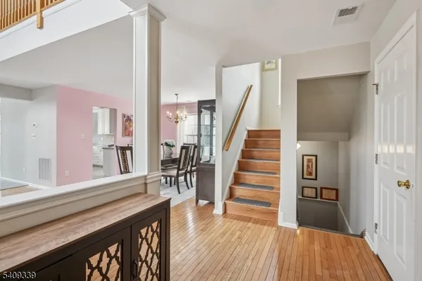 a view of a hallway with wooden floor and staircase