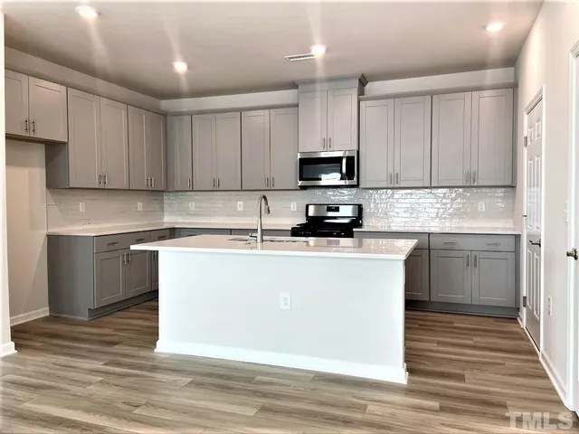a kitchen with a sink a stove and cabinets