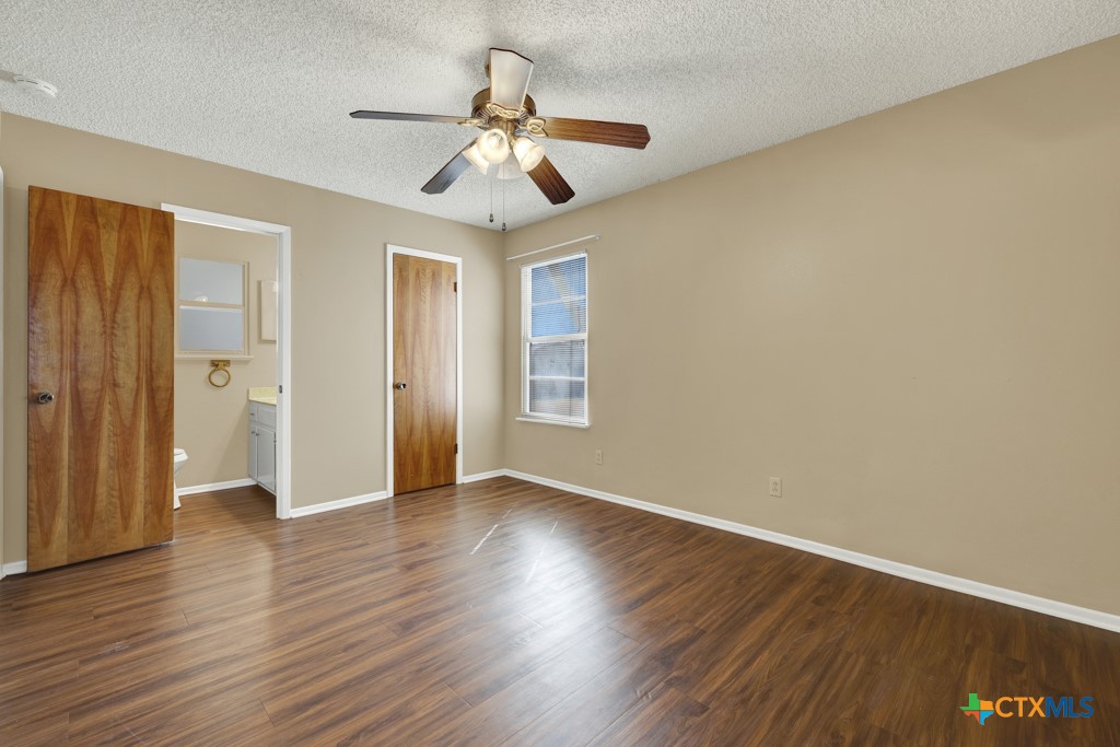 217 Gruene Road New Braunfels, TX 78130 - Photo 12 of 25 a view of an empty room with wooden floor and a ceiling fan