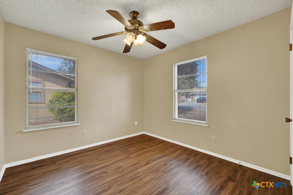 217 Gruene Road New Braunfels, TX 78130 - Photo 15 of 25 a view of an empty room with wooden floor and a window