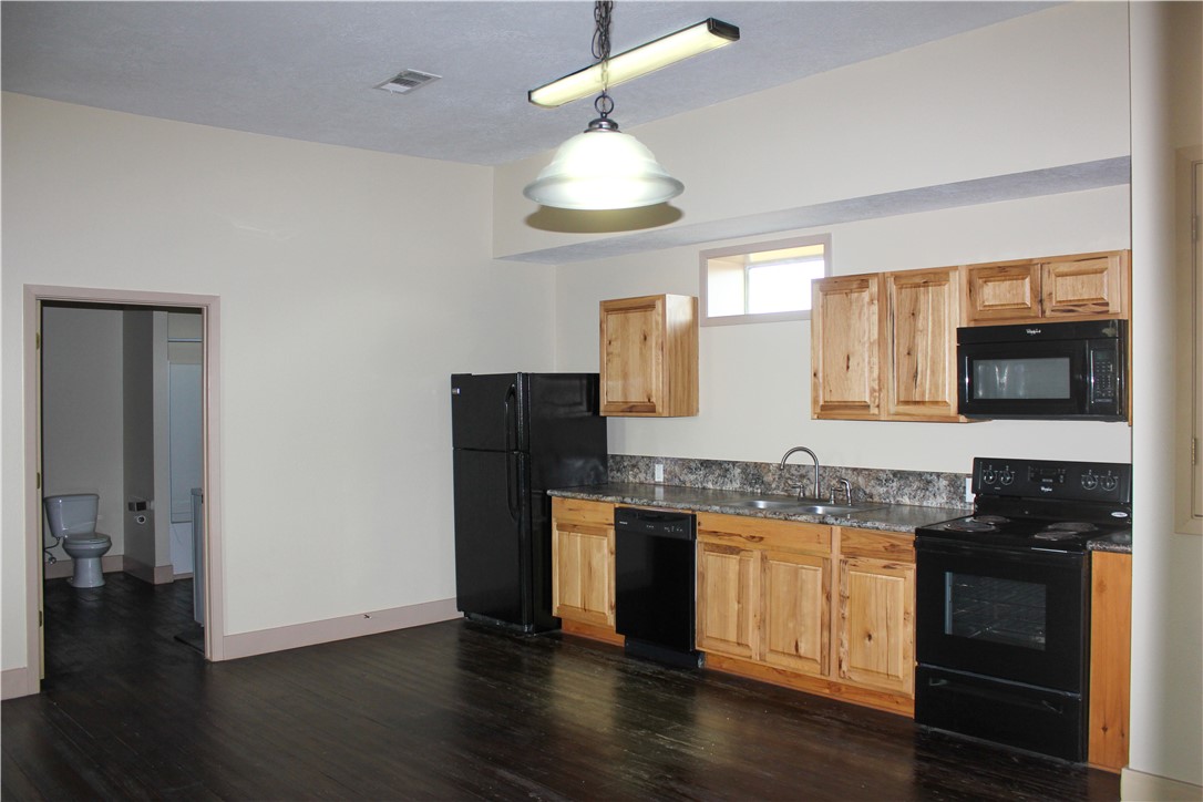 205 South Main Street Caldwell, TX 77836 - Photo 7 of 12 a kitchen with stainless steel appliances granite countertop a stove and a refrigerator