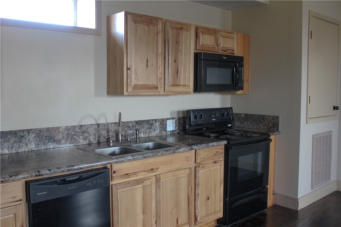 205 South Main Street Caldwell, TX 77836 - Photo 8 of 12 a kitchen with stainless steel appliances granite countertop a sink stove and microwave