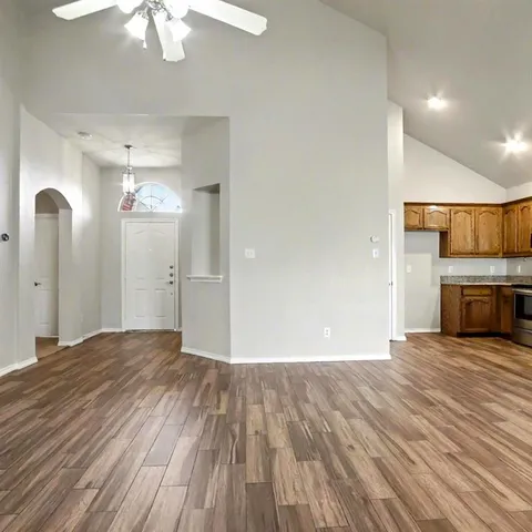 a view of empty room with wooden floor and fireplace