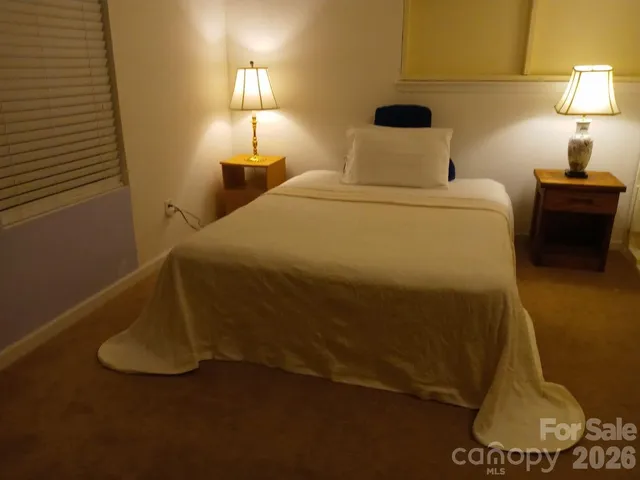 a bedroom with a bed and a lamp