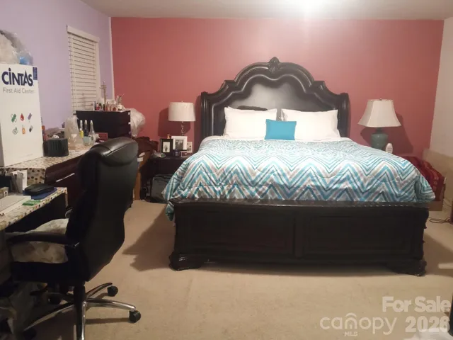 a large bed sitting in a bedroom next to a window