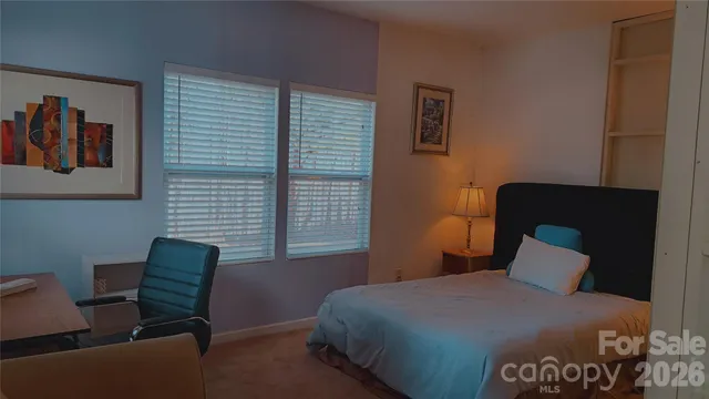 a bedroom with a bed and a chair with potted plant