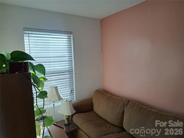 a blue couch sitting in a living room next to a window