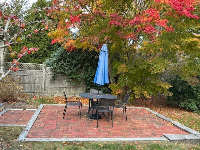 544 Cotuit Road Marstons Mills, MA 02648 - Photo 44 of 52 a view of backyard with table and chairs and wooden fence