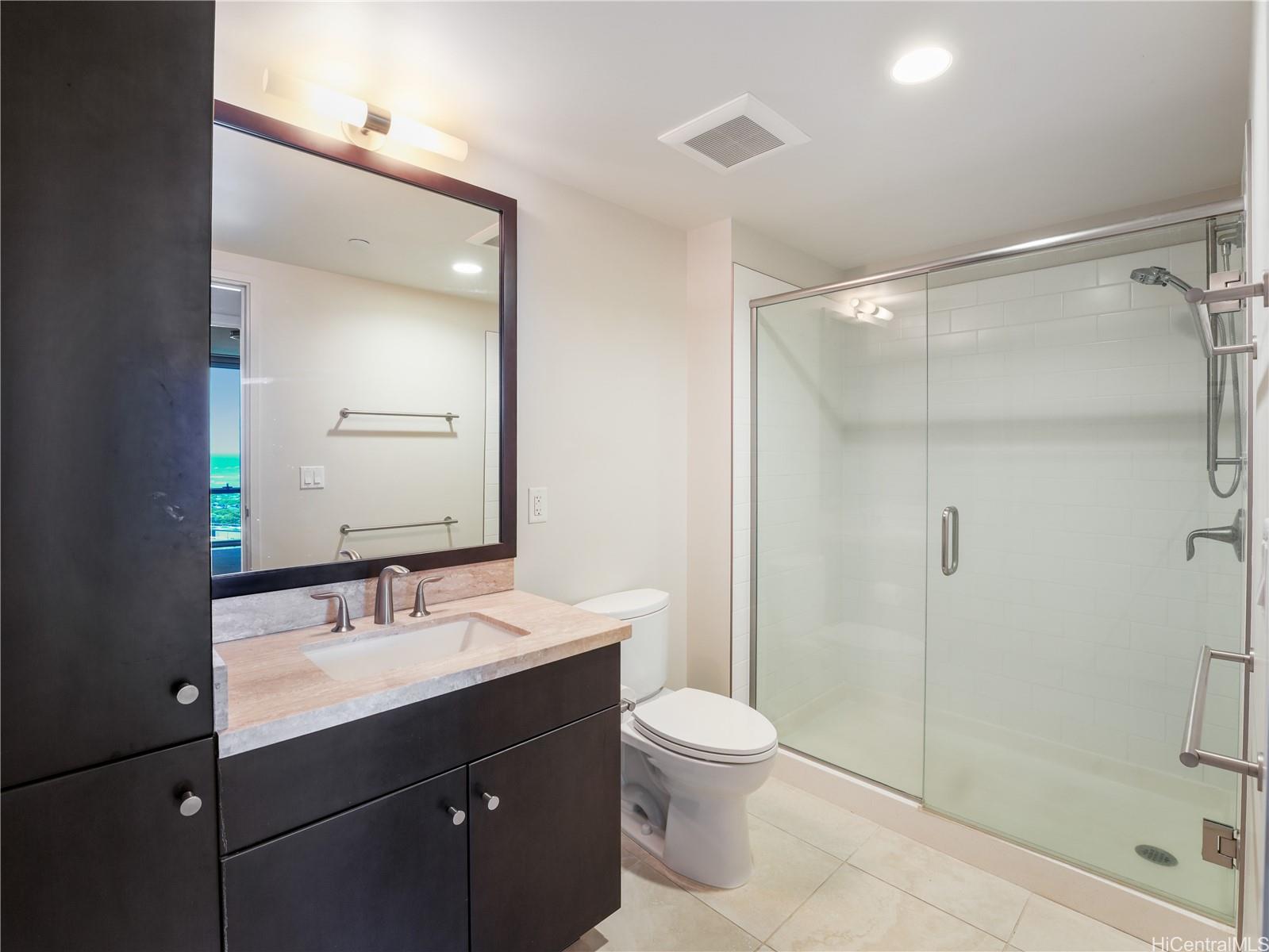 1189 Waimanu Street, Unit 2204 Honolulu, HI 96814 - Photo 12 of 17 a bathroom with a sink mirror toilet and shower