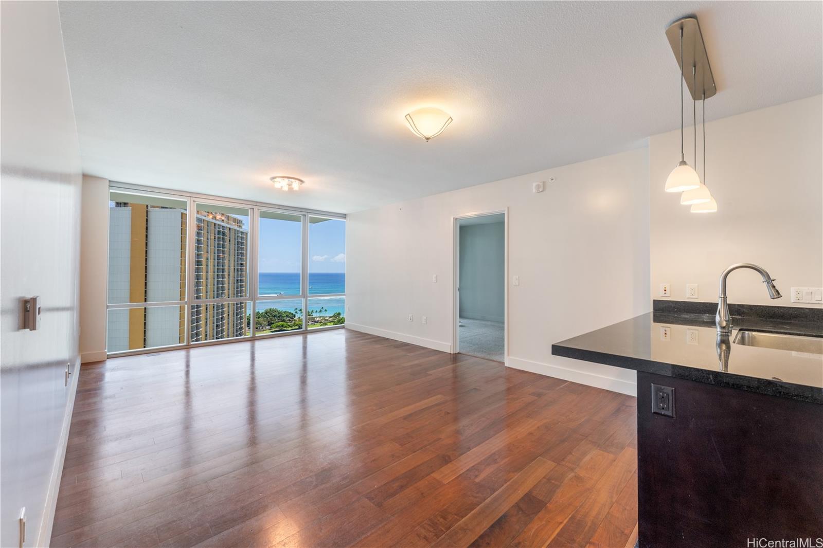 1189 Waimanu Street, Unit 2204 Honolulu, HI 96814 - Photo 2 of 17 a view of a kitchen with a sink and dishwasher with wooden floor