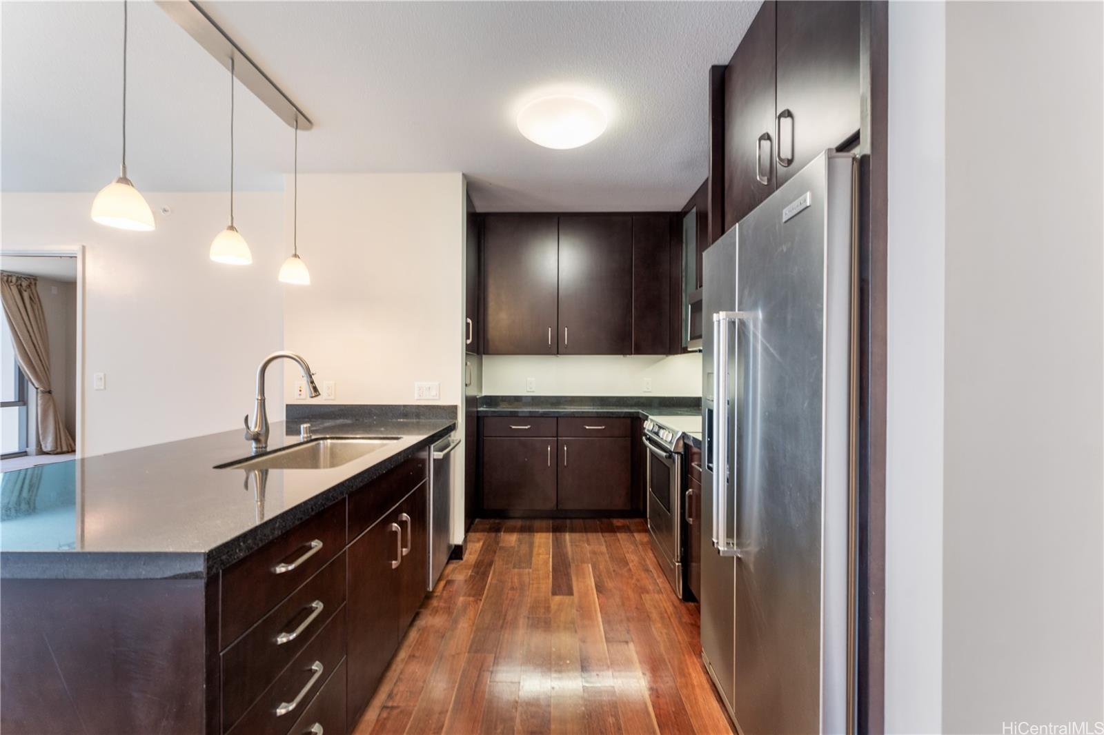 1189 Waimanu Street, Unit 2204 Honolulu, HI 96814 - Photo 4 of 17 a kitchen with a sink and a refrigerator