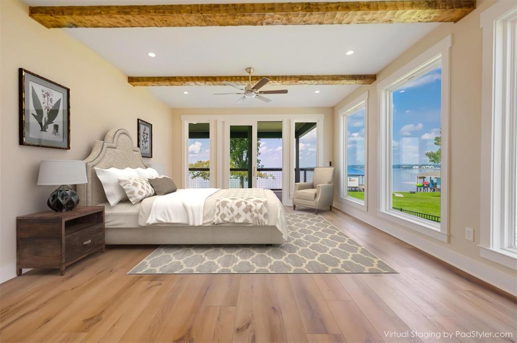 22107 Blue Water Road Chandler, TX 75758 - Photo 16 of 40 a spacious bedroom with a large bed and a wooden floor