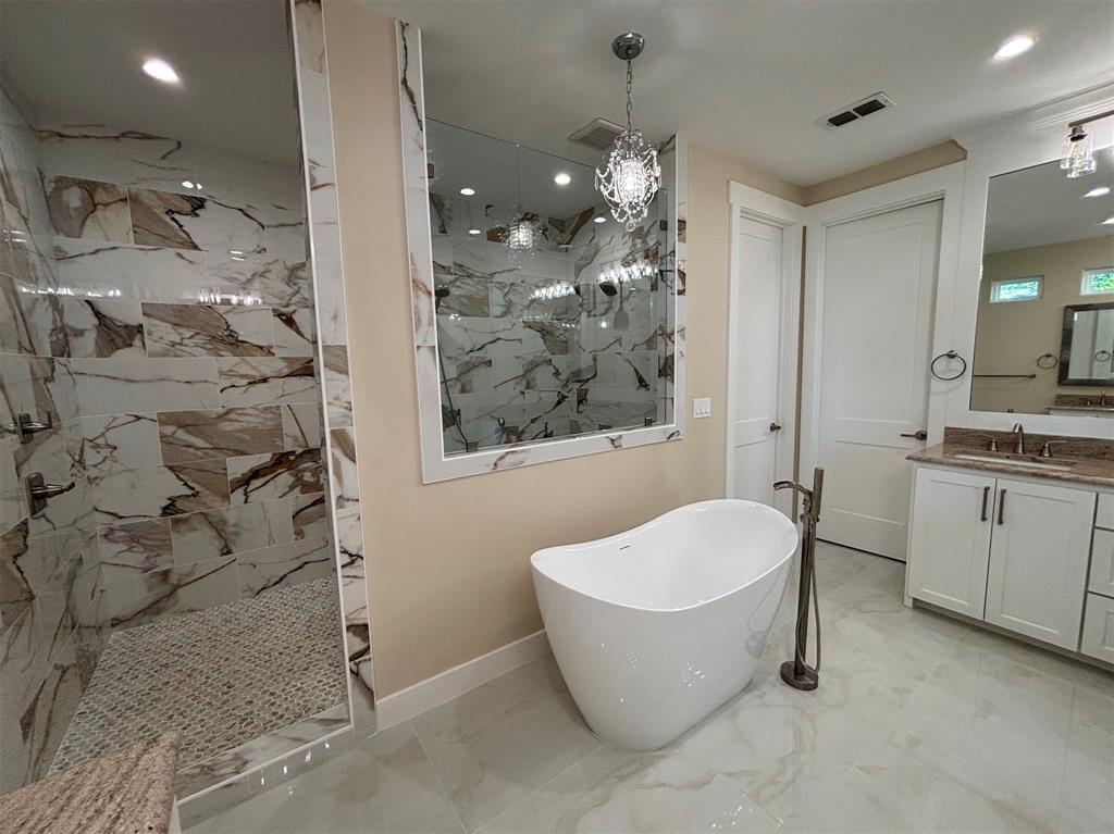 22107 Blue Water Road Chandler, TX 75758 - Photo 18 of 40 a bathroom with a bathtub a toilet a shower a sink and mirror