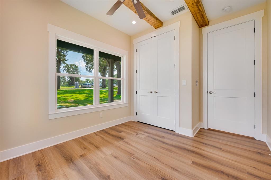 22107 Blue Water Road Chandler, TX 75758 - Photo 22 of 40 a view of empty room with wooden floor and fan