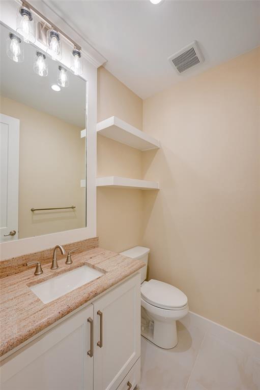 22107 Blue Water Road Chandler, TX 75758 - Photo 23 of 40 a bathroom with a granite countertop sink a toilet and a mirror