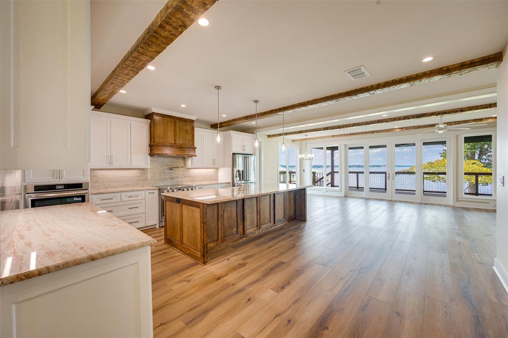 22107 Blue Water Road Chandler, TX 75758 - Photo 5 of 40 a kitchen with stainless steel appliances granite countertop a lot of cabinets and wooden floor