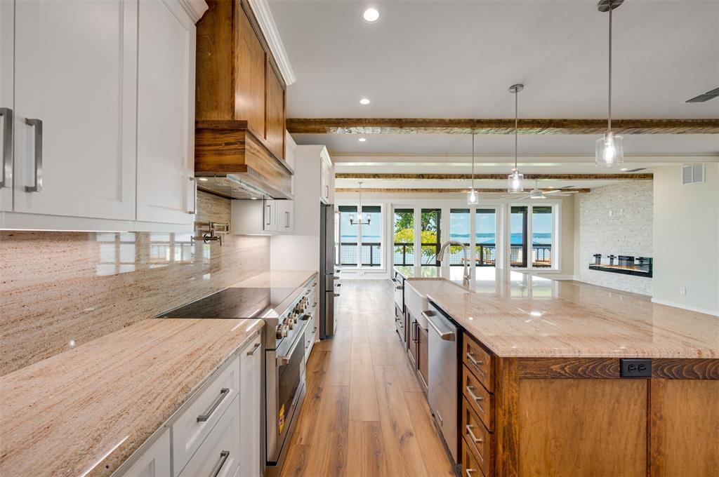 22107 Blue Water Road Chandler, TX 75758 - Photo 7 of 40 a kitchen with granite countertop a sink a counter top space and stainless steel appliances