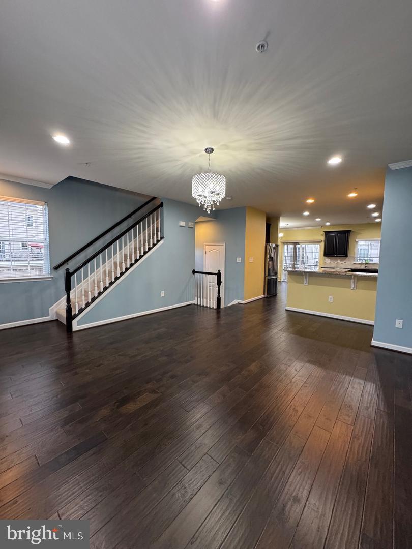 7925 Alchemy Way Elkridge, MD 21075 - Photo 18 of 46 a view of a room with wooden floor staircase and a kitchen