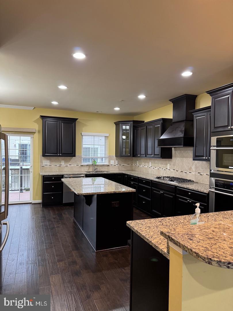 7925 Alchemy Way Elkridge, MD 21075 - Photo 20 of 46 a kitchen with stainless steel appliances granite countertop wooden cabinets counter top space and a center island