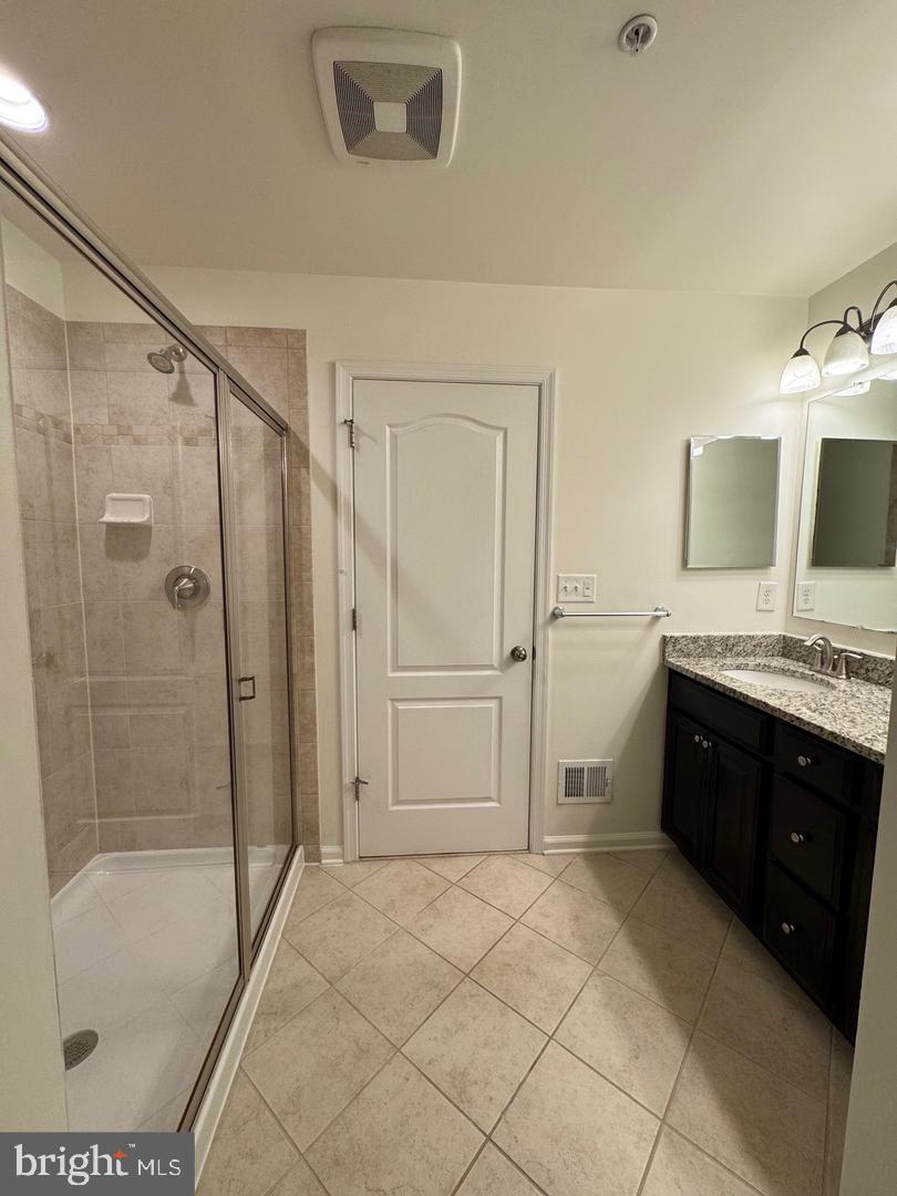 7925 Alchemy Way Elkridge, MD 21075 - Photo 34 of 46 a spacious bathroom with a granite countertop sink a mirror and a bathtub