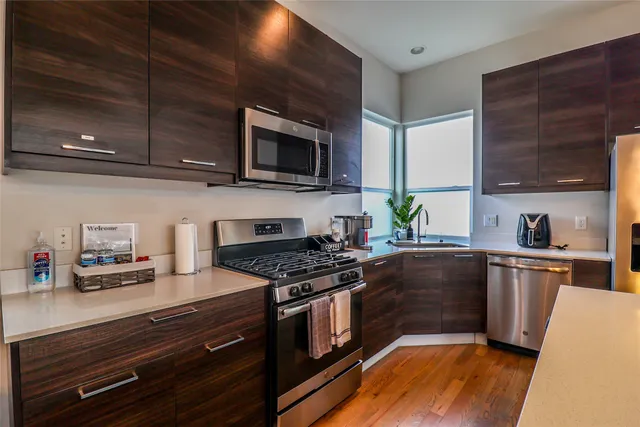 a large kitchen with stainless steel appliances a large counter top
