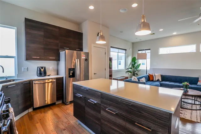 a living room with furniture kitchen view and a large window